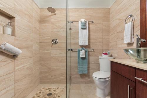 a bathroom with a shower with a toilet and a sink at Karana Studio 2 - K2 in Long Bay Hills