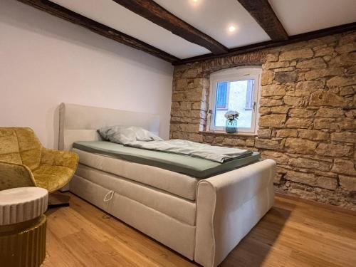 a bedroom with a bed and a couch and a window at Apartment in Herbolzheim in Herbolzheim