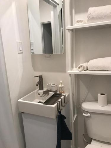 a white bathroom with a sink and a toilet at Casa Nostra Vagón in Coamo