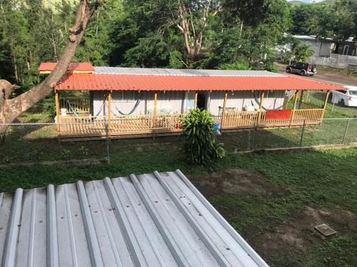 a house with an orange roof in a yard at Casa Nostra Vagón in Coamo