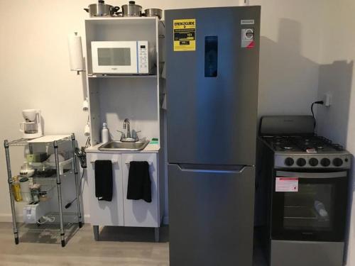 a kitchen with a refrigerator and a sink and a microwave at Casa Nostra Vagón in Coamo