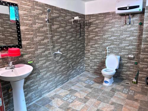 a bathroom with a shower and a toilet and a sink at A Tứng House Bản Giốc in Trùng Khánh