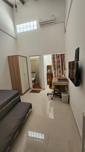 a room with a bed and a tv in it at Cute Room at Pondok Raima SYARIAH in Gresik