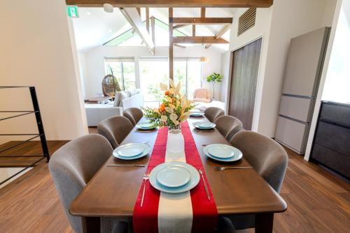 a dining room with a long table and chairs at Hakuba Villa Kasumi in Hakuba