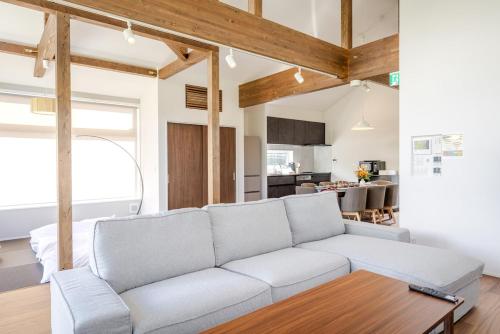 a living room with a couch and a table at Hakuba Villa Kasumi in Hakuba