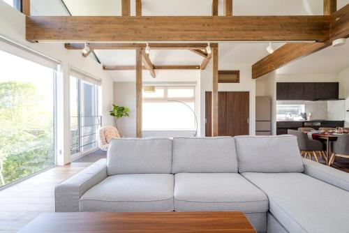 a living room with a couch and a kitchen at Hakuba Villa Kasumi in Hakuba