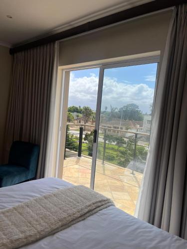 a bedroom with a bed and a sliding glass door at Private Rooms - home-stay in Gqeberha