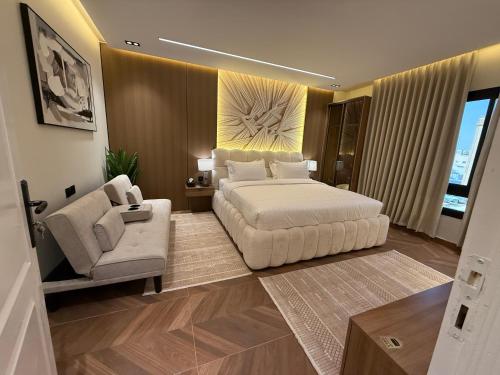 a bedroom with a bed and a couch and a chair at الملقا جاكوزي لوفت Al Malqa Jacuzzi Loft in Riyadh