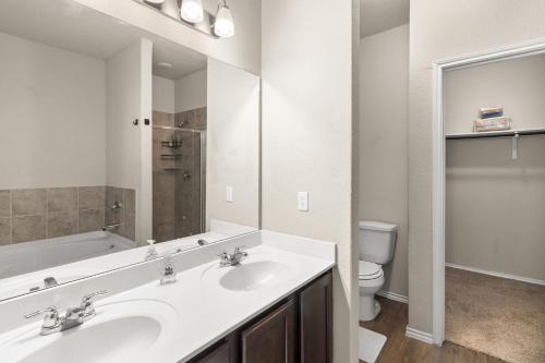Un baño con dos lavabos y un inodoro. en 5BR Furnished Stay Near Randolph AFB & Hospitals, en Cibolo