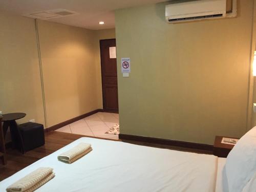 a hotel room with a bed and a wall at Nawaporn Place in Phuket Town
