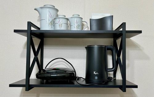 a black shelf with a tea kettle and dishes on it at ApComplete in the center in Caxias do Sul