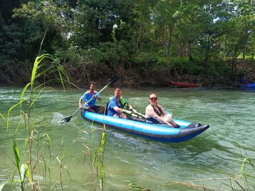 three men in a blue canoe on a river at Khaosok Creek and Jungle Resort in Ban Song Phi Nong