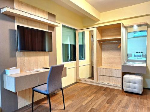 a room with a desk with a chair and a television at ปาวาติ ชีวา เขาใหญ่ Parvati Chiva Khaoyai in Nong Sarai