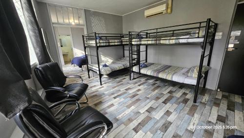 ミルデューラにあるSunraysia Staysの二段ベッド2台と椅子2脚のある部屋