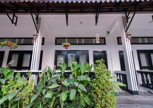 un edificio bianco con delle piante di fronte di Soksan Villa a Battambang