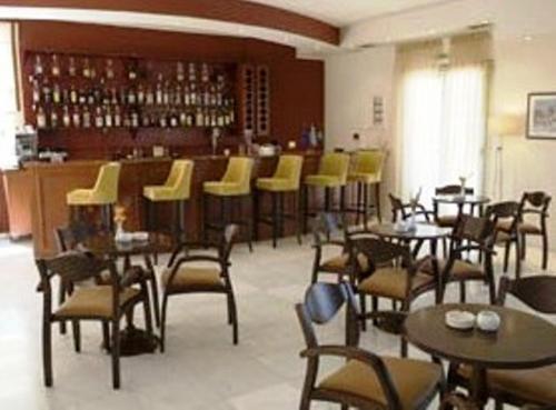 a restaurant with tables and chairs and a bar at Kornilios Istron Hotel in Giannitsa