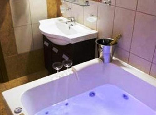 a bathroom with a bath tub and a sink at Kornilios Istron Hotel in Giannitsa