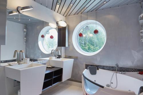baño con 2 lavabos, bañera y 2 ventanas en Villa Moderna, en Jūrmala