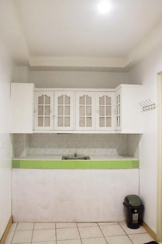 a kitchen with white cabinets and a sink at Ace Travellers Inn- Palawan in Puerto Princesa City