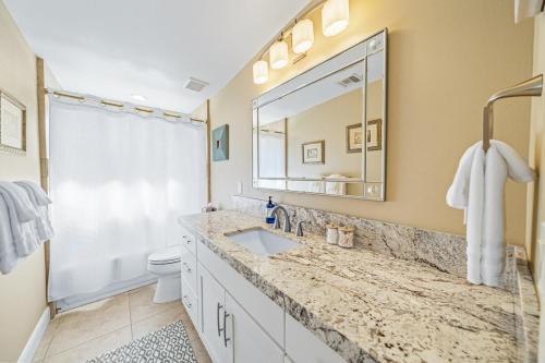 a bathroom with a sink and a toilet and a mirror at Chill-Inn, an Indian Wells Oasis in Indian Wells