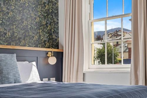 a bedroom with a bed and a window at Portsea Place - designer king studio and parking in Hobart