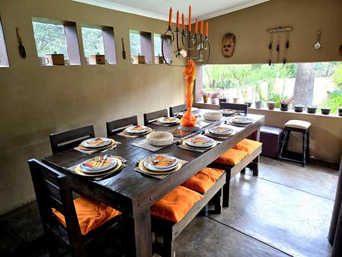 a long wooden table with chairs and food on it at El-Tsuri Guest Resort in Pretoria