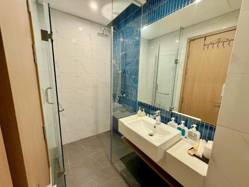 下龙湾Chuỗi căn hộ ICON40 Bãi Cháy, gần biển的浴室配有洗手池和玻璃淋浴房