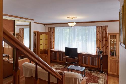 a living room with a staircase and a television at Villa Moderna in Jūrmala