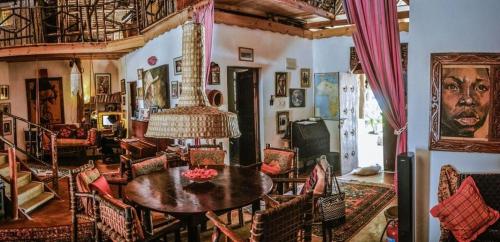a living room with a table and chairs and a chandelier at Utupoa in Matemwe