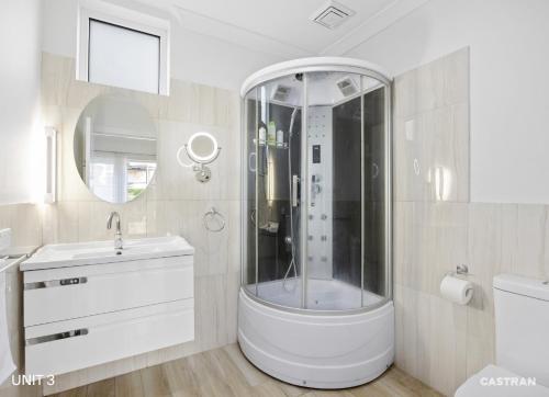 a white bathroom with a shower and a sink at Merry Mary in Marysville