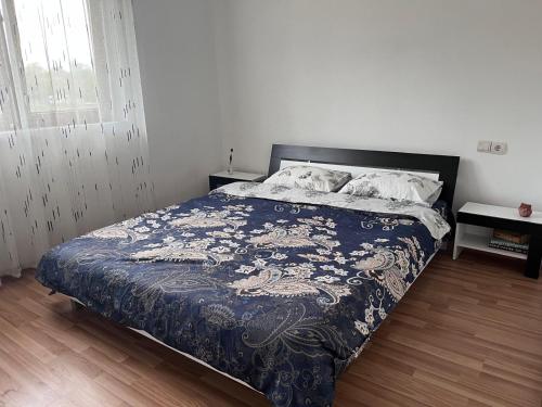 a bedroom with a bed with a blue comforter at Casa Isabela in Ocna Sibiului
