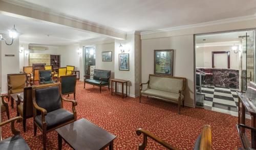 a waiting room with chairs and tables and a mirror at Galaxy Beach Hotel Alanya in Mahmutlar