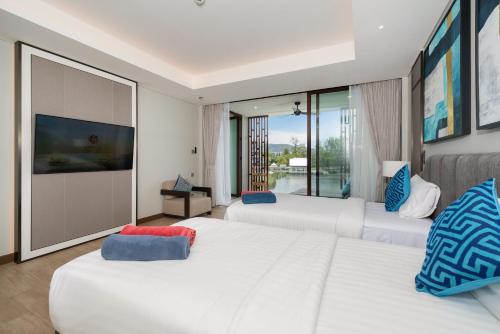 a hotel room with two beds and a balcony at Luxury Infinity Sky Pool Suite Angsana Laguna Lakeside in Phuket Town