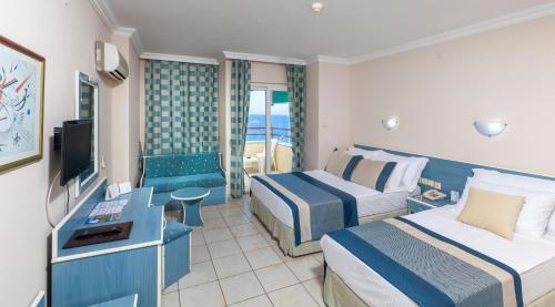 A bed or beds in a room at Galaxy Beach Hotel Alanya