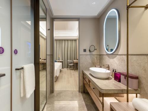 成都市にあるMercure Chengdu Shuangliu International Airportの洗面台と鏡のあるバスルーム