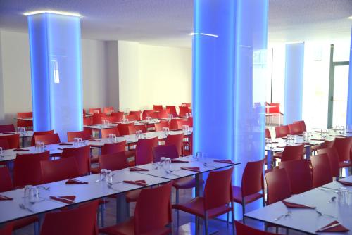 a large room with tables and red chairs at Hostal El Júcar in Alcalá del Júcar