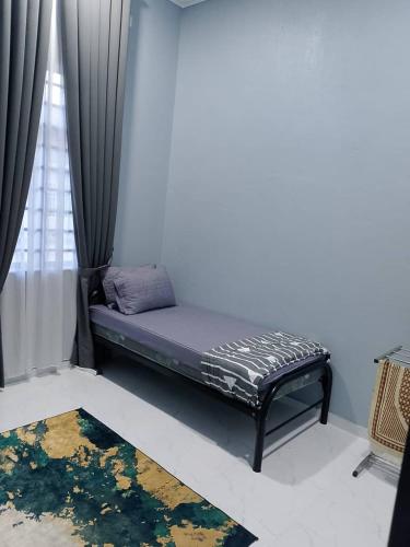 a bed sitting in a room with a window at HomeStay Rafiza in Jertih