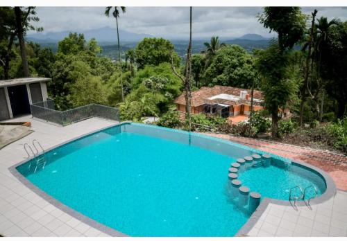 Una gran piscina azul frente a una casa en Chills homestay, en Kalpetta