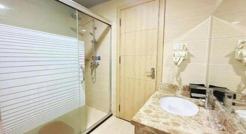 une salle de bain avec un lavabo et une douche dans l'établissement Bashan Hotel, à Xiamen