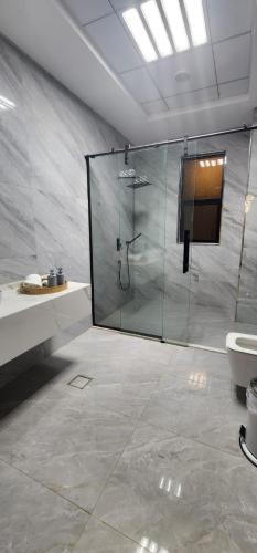 a bathroom with a glass shower and a toilet at EkDatta-Irving in Ajman 