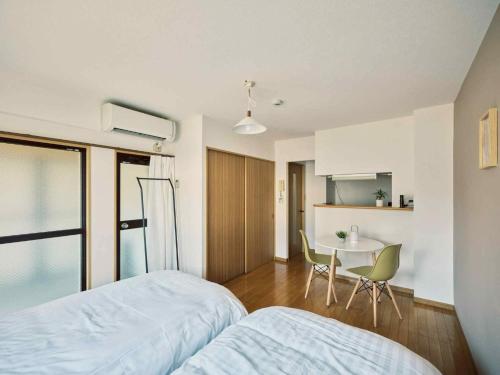 a bedroom with a bed and a table in it at vetta kumamoto suizenji2 204 in Kumamoto