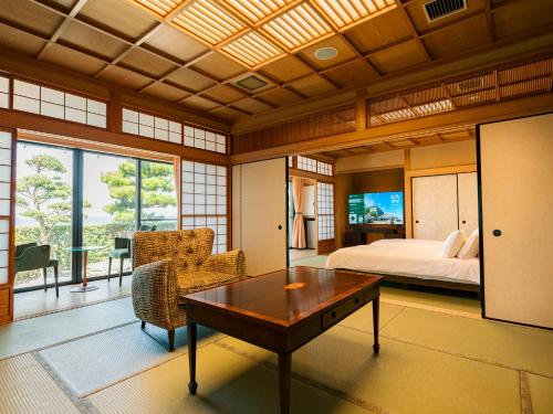 une chambre avec un lit et une table dans une pièce dans l'établissement 洗心和方 Senshin Waho, à Awaji