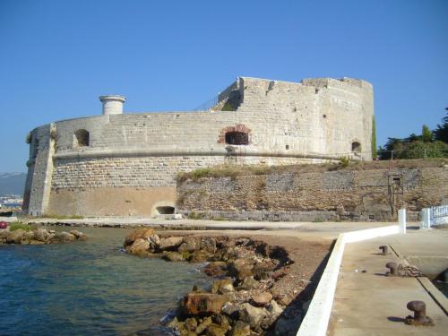 a large castle sitting next to a body of water at Ibis Budget Toulon Centre in Toulon