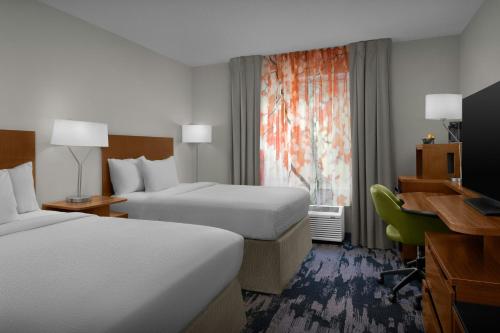 ein Hotelzimmer mit zwei Betten und einem Schreibtisch in der Unterkunft Fairfield Inn and Suites by Marriott Emporia I-95 in Emporia