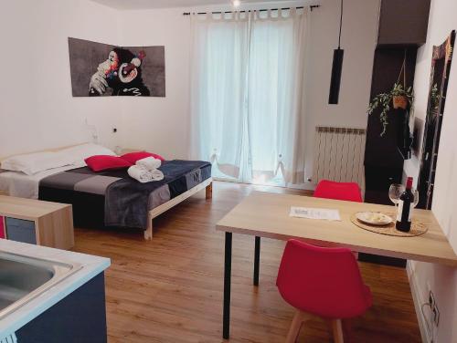 een slaapkamer met een bed en een tafel met rode stoelen bij Careggi apartment in Florence