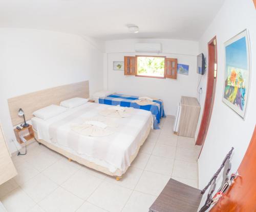 a bedroom with a large bed and a window at Vila do Galo in Porto De Galinhas