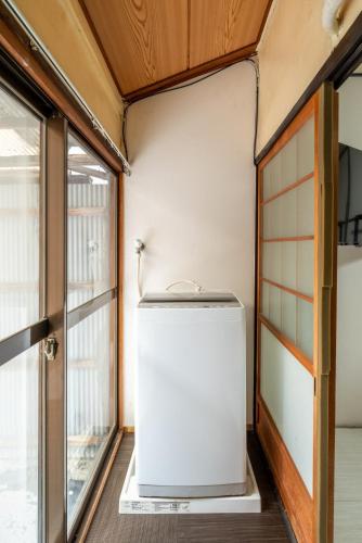 a small refrigerator in a room with a window at A comfortable house with easy access to Osaka city in Osaka