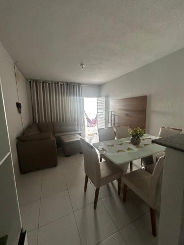 a living room with a table and chairs and a couch at Casa de ferias Tarciane Horizonte Ceara in Horizonte