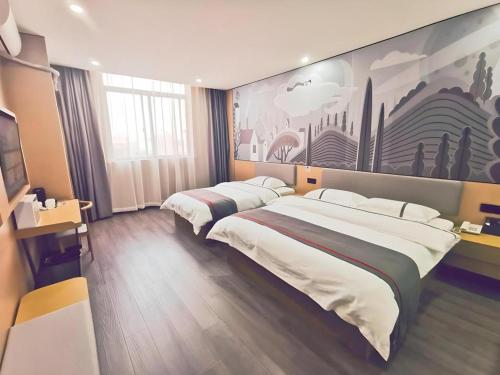 a hotel room with two beds and a painting on the wall at Thank Inn Plus Hotel Jiangyin University in Wuxi