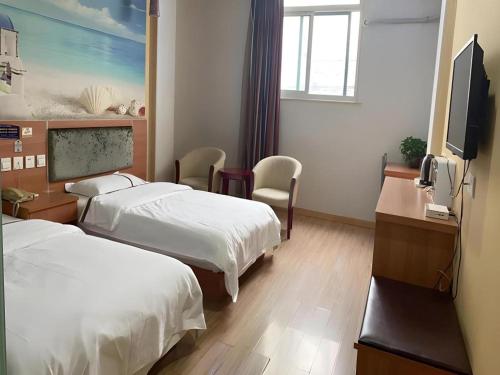 a hotel room with two beds and a flat screen tv at Thank Inn Plus Hotel Jiangyin University in Wuxi